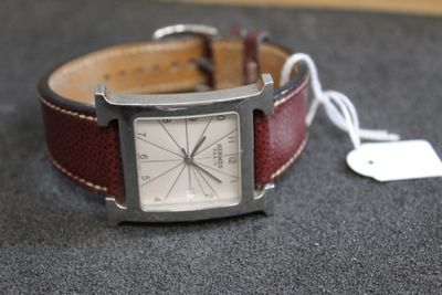 une montre posée sur une table à côté d'une étiquette