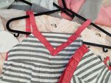 a lot of clothes on a hanger on a bed