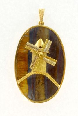 une image représentant un pendentif en or orné d'un moulin à vent