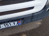 a close up of a white truck with a license plate on it
