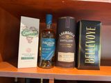 deux bouteilles d'alcool et une boîte de vin sur une étagère