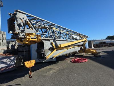 une grue est garée sur un parking à côté d'un immeuble