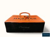 an orange suitcase with writing on it sitting on a white surface