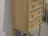 a small chest of drawers with a mirror on top of it