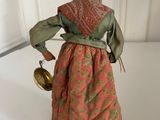 an image of a figurine of a woman with a bell in her hand