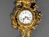une horloge dorée accrochée au mur sur fond noir