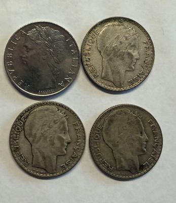 four different british coins sitting on top of a white surface