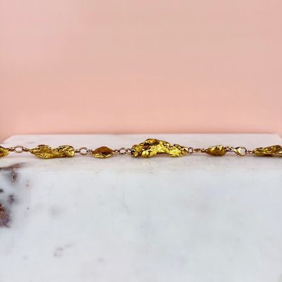 a picture of a gold plated chain with leaves on it