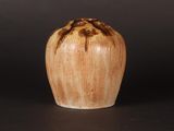 a brown and white vase sitting on a black surface