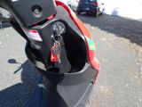 a red and black scooter parked on the side of the road