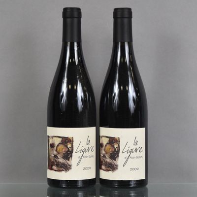 two bottles of wine sitting on top of a table next to each other