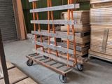 several pallets of wood are stacked on a dolly in a warehouse