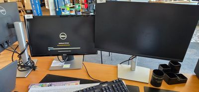 a computer monitor and keyboard on a desk in a library
