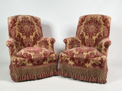 paire de fauteuils rembourrés rouges et dorés aux accoudoirs à volants