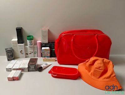 une photo montrant un sac à main rouge, un chapeau et d'autres objets posés sur une table