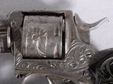 a silver revolver with a black handle on a white surface