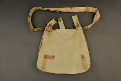 an old canvas bag with two straps and a brown strap