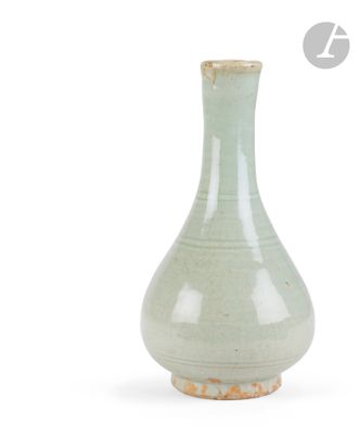 a green vase that is sitting on a white surface