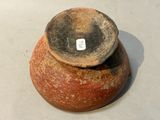 a brown vase with a tag on it sitting on a table