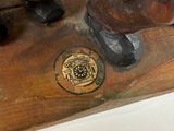 a wooden statue of a bear with a medallion on it