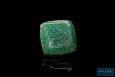 a close up of a green stone on a black surface