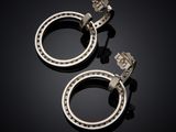 a pair of silver hoop earrings on a black surface