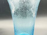 a blue glass vase sitting on a table