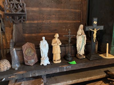 many statues of jesus and other religious figures on a shelf