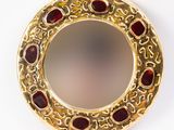 une image montrant un gros plan d'une bague en or sertie de pierres rouges