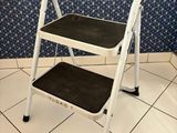 two step stools in a bathroom with blue and white wallpaper
