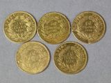 four gold coins with the names of different countries on them