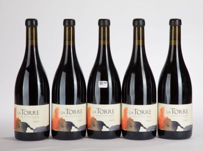 four bottles of wine are lined up on a white surface