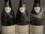 three bottles of wine wrapped in plastic sitting on top of a table