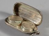 a silver case with two coins in it on a table