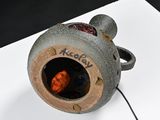 a gray vase with a red light inside of it