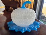a white vase with a blue top on a table