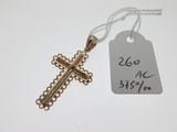 a small gold cross on a white table with a price tag