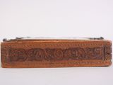 an old wooden box with a metal handle on a white surface