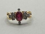 a close up of a gold ring with a ruby stone