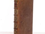 an old book sitting on top of a table next to a white wall