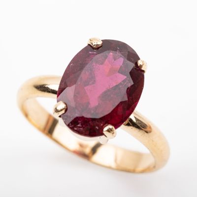 a close up of a ring with a red stone in it