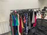 a lot of clothes hanging on a rack in a room