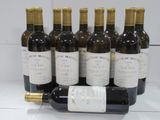 six bottles of wine are lined up in a row on a counter