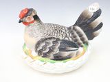 une figurine représentant un poulet posé sur une assiette
