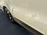 a white car that has been damaged and is parked on the side of the road