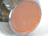 a glass jar with a brown substance inside of it