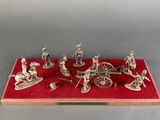 silver figurines of soldiers and horses on a red display case