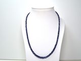collier composé de perles de verre bleues sur un mannequin blanc
