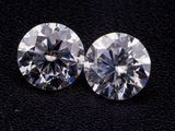 deux diamants taille ronde sur un fond noir
