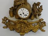a gold clock sitting on top of a marble base
